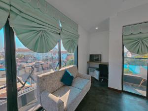 Ultimate Boutique في سيام ريب: غرفة معيشة مع أريكة ومظلة