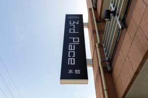 a sign on the side of a building at HOTEL Third Place Hakata in Fukuoka