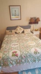 1 dormitorio con 1 cama con edredón en Cozy, cute beach condo in Westerly RI . Best value in Westerly!!, en Westerly