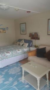 a bedroom with a bed and a table and a couch at Cozy, cute beach condo in Westerly RI . Best value in Westerly!! in Westerly