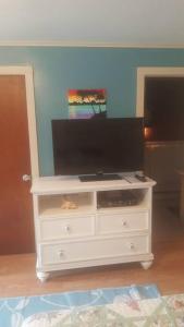 una cómoda blanca con una TV encima en Cozy, cute beach condo in Westerly RI . Best value in Westerly!! en Westerly