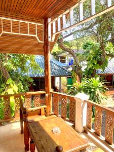 a wooden deck with a wooden table and chairs on a porch at Koh Tao Tropicana Resort in Koh Tao