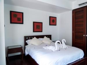 a bedroom with a white bed with swans on it at 3 Bedroom Seaview Villa Haven on Beachfront Resort in Koh Samui 