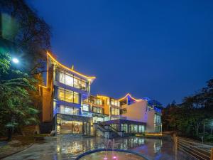 un grand bâtiment avec des lumières allumées la nuit dans l'établissement Drunken Valley Manor - Zhangjiajie National Forest Park, à Zhangjiajie