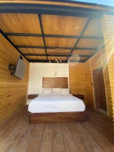 Schlafzimmer mit einem Bett mit Holzdecke in der Unterkunft Real Carretero in Tapalpa