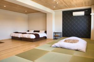 a bedroom with two beds and a rug at Tabist Hotel Chouseikaku in Yatsushiro