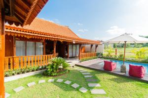 un’immagine di una casa con piscina e ombrellone di Rara Villa a Canggu