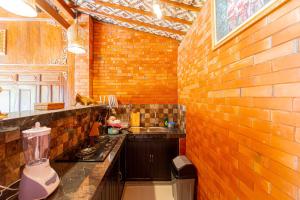 eine Küche mit einer Theke und einer Ziegelwand in der Unterkunft Rara Villa by Bukit Vista in Canggu