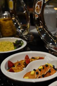 un plato de comida con fruta en una mesa en Aqueen Hotel Paya Lebar, en Singapur