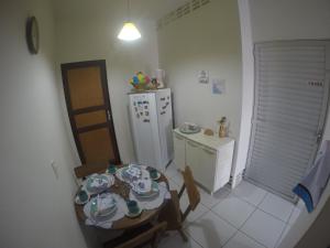 una pequeña cocina con una mesa con platos. en Casas Maragogi 1, en Maragogi