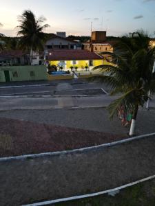 una calle vacía con una palmera en primer plano en Casa Amarela Paripueira, en Paripueira