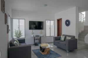 sala de estar con 2 sofás y TV en Villa Golden Dream, en San Felipe de Puerto Plata
