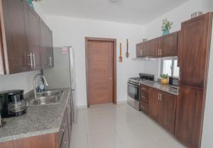 uma cozinha com armários de madeira, um lavatório e um fogão em Villa Golden Dream em San Felipe de Puerto Plata