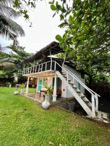 a house with a staircase leading up to it at Beach House Kalukatiya - Family Villa, Seaview Room, Garden Room in Dickwella