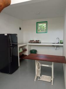 a kitchen with a table and a black refrigerator at Beach House Kalukatiya - Family Villa, Seaview Room, Garden Room in Dickwella +82 photos