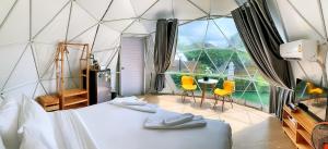 a room with a bed and a large window at Glamping hill khaoyai in Khao Yai