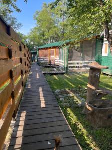 a wooden walkway leading to a building with a fence at RAINBOW HOME in Gornji Štoj