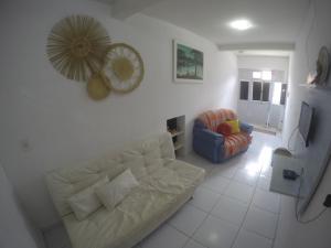 sala de estar con sofá blanco y silla en Casas Maragogi 2, en Maragogi