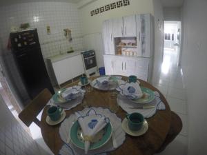 una cucina con tavolo in legno e stoviglie di Casas Maragogi 2 a Maragogi