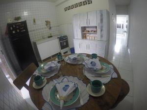 una cocina con una mesa de madera con platos. en Casas Maragogi 2, en Maragogi