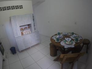 una camera con tavolo in legno, tavolo e sedie di Casas Maragogi 2 a Maragogi Altre 2 foto