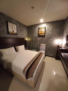 1 dormitorio con 1 cama grande en una habitación en GM Hotel, en Changlun