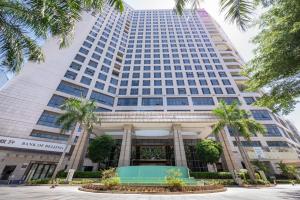 a tall building with palm trees in front of it at Lia Charlton Hotel Shenzhen in Shenzhen