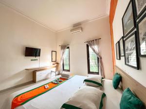 a living room with a bed and a tv at Homestay Sawitsari Dekat Pakuwon Mall dan UGM by Simply Homy in Yogyakarta