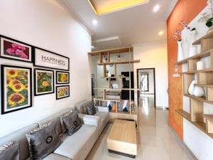 a living room with a couch and a table at Homestay Sawitsari Dekat Pakuwon Mall dan UGM by Simply Homy in Yogyakarta