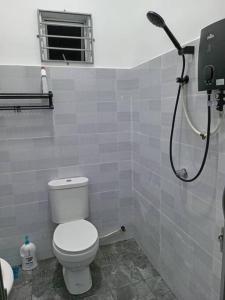 a bathroom with a toilet and a shower at Homestay Restu Mak Abah Private Pool Melaka in Merlimau