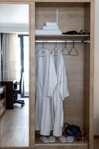 un armario con ropa blanca colgando en una habitación en Coresi rezidence & suites, en Brasov 24 fotos más