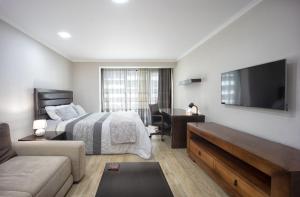 a bedroom with a bed and a flat screen tv at Coresi rezidence & suites in Braşov
