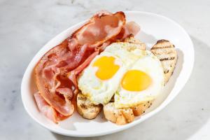 - un plateau de petit-déjeuner composé d'œufs, de bacon et de pain dans l'établissement Wildes Hotel Kangaroo Valley, à Kangaroo Valley
