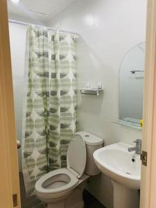 a bathroom with a toilet and a sink at The Midpoint Residences in Mandaue City