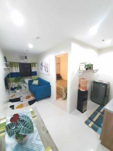 a living room with a blue couch and a television at The Midpoint Residences in Mandaue City