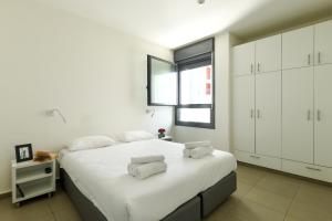 a white bedroom with a large bed with white cabinets at דירות גני תערוכה - TLV university apartments near Expo by Sea N' Rent in Tel Aviv