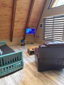 a living room with a couch and a flat screen tv at Deume alpina in Chillán