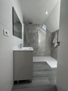 ein weißes Bad mit einem Waschbecken und einer Dusche in der Unterkunft Casa Rosquillas in Vilanova de Arousa