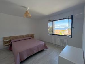 ein Schlafzimmer mit einem Bett und einem großen Fenster in der Unterkunft Casa Rosquillas in Vilanova de Arousa