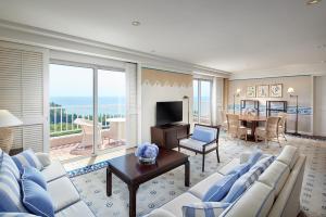 a living room with blue and white furniture and a table at The Shilla Jeju in Seogwipo