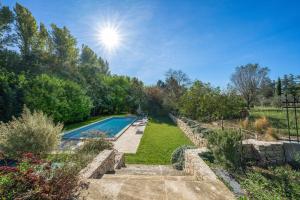 un patio trasero con piscina y jardín en APPARTEMENT DERNIER ETAGE DANS BASTIDE en Aix-en-Provence