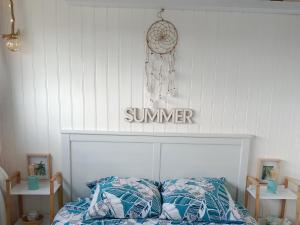 sypialnia z łóżkiem z letnim znakiem na ścianie w obiekcie L'Océan&Dunes vue à 180° en bord de plage w mieście Lacanau-Océan