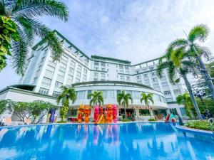 a hotel with a large pool in front of a building at Sai Gon Rach Gia Hotel in Rach Gia