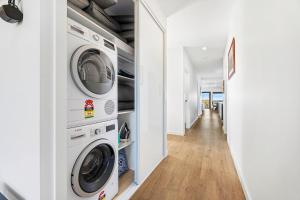 Montague Sunrise 2 Riley Street Narooma في ناروما: غرفة غسيل مع غسالتين ومجفف