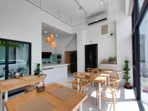 a room with tables and chairs and a kitchen at Kenting Onehome in Checheng