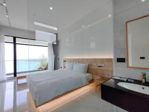 a bedroom with a bed and a sink and a mirror at Kenting Onehome in Checheng