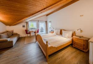 a bedroom with a large bed and a couch at Gästehaus Döring in Mittenwald