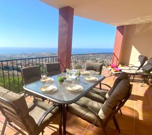 a dining room with a table and chairs on a balcony at Villa Romeo, with brand new salt water pool in Benalmádena