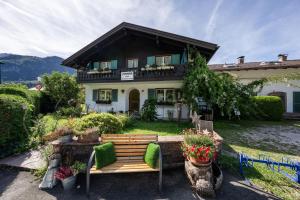 une maison avec un banc devant elle dans l'établissement Gästehaus Döring, à Mittenwald