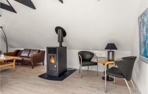 a living room with a fireplace and chairs and a couch at Lovely Apartment In Hemmet in Hemmet
